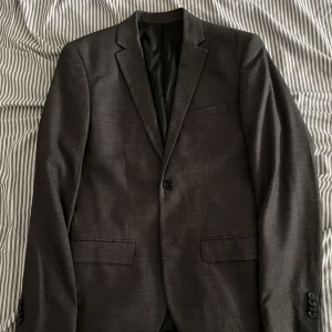 Kavaj HM - En mörkgrå kavaj från HM.  Aldrig använd. Storlek M