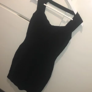 Bandana klänning - Svar bandana klänning som formar kroppen. Strl L. Dragkedja baktill, sömmen har gått upp lite bak i nacken se sista bilden men inget som stör funktionen och syns inte om man har håret utsläppt. 