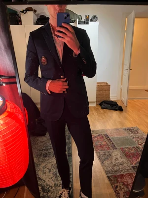 Morris blazer - Schysst marinblå blazer från Morris. Storlek 48 med stort emblem på bröstet. Knappt använd men behöver eventuellt strykas.