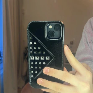 Jättefint skal från ideal of Sweden  - Lånade bilder! Jag säljer ett jättefint ideal of Sweden skal till en iPhone 12. Skalet är svart med silvriga nitar och har en korthållare. Endast testat, säljer eftersom det inte passar min telefon. Skriv för fler bilder.