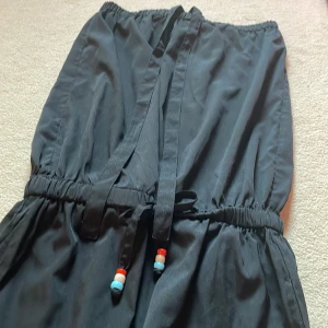 Svart dress  - Jättefin dress i nyskick. Är helt oanvänd eftersom att den var för stor för mig. Fin till sommaren och den är väldigt luftig och har tunnt tyg. Kan knytas i nacken och vid anklarna.