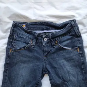 Lågmidjade jeans från Lee i bra skick. Rak, med något utsvängt i modellen. Färgen är lite grå/blå. Strl 27/31 Midja: 35 cm Innerbenslängd: 77 cm Ytter: 96 cm