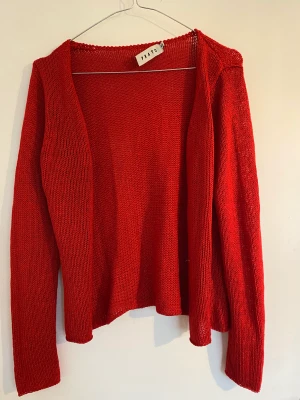 Fin röd kofta - Röd stickad kofta i en fin röd färg, gansk tunnt stickad, bra kvalite. Knappt använd.