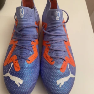 Fotbollsskor puma  - PUMA future FG/AG supercharge - blå/vit/organge. De är helt nya och Endast använda en gång och är i bra skick. Säljer på grund av att de är i fel storlek nypris 1600 kr pris går att diskutera