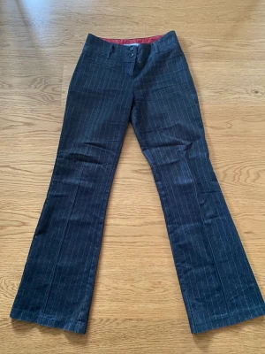 Raka randiga kostymbyxor - Midwaist kostymbyxor med kritstrecksrand i en rak modell. 