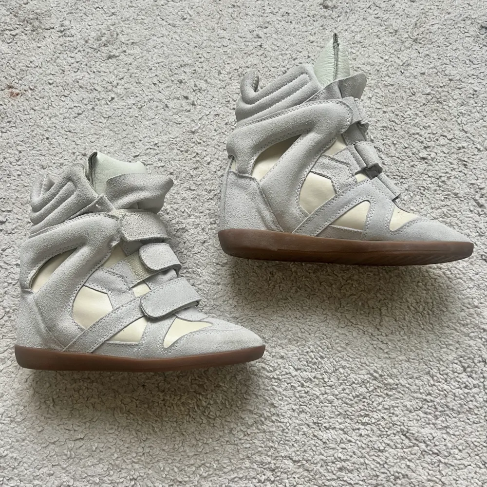 Vita / grå - beigea Isabel marant skor i storlek 37! Skorna är i nyskick förutom en liten rivning på den vänstra skon, ses på sista bilden - annars helt nya. Kan mötas i stockholm eller frakta, tryck gärna köp nu⭐️⭐️. Skor.