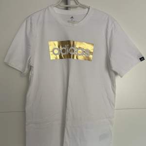 Oanvänd adidas t-shirt med glänsande guldtryck