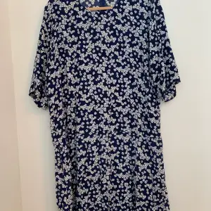 Nästintill oanvänd blå och vit blommig klänning från Samsøe & Samøe i storlek M. Klänningsmodell heter ”Adelaide dress”, och färgen/mönstret heter ”Daisy Blue”. Klänningen har fickor och är endast använd 1 gång. Nypris 1199kr.