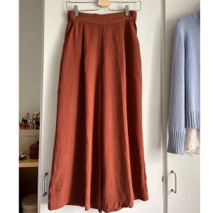 Culottebyxa - Byxa i vid culotte-modell från H&M. Roströd färg. Väldigt flowy och sköna. Rejäl resår i midjan. Fickor. Passr xs/s. 