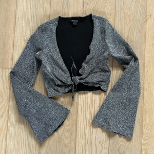 Glittrig tröja - Sjukt snygg glittrig tröja med knytning och utsvängda ärmar från Monki! 🩶Bara använd en gång, perfekt till fest!
