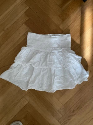 Kort kjol med volang stl 152 - Vit kjol med volang, jättefint skick. Inköpt på Kappahl, stl 152 men passar också 158.