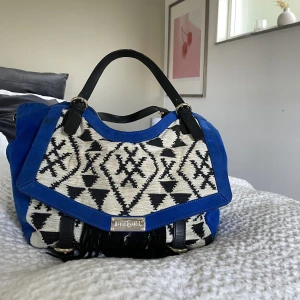Desigual väska  - En så unik o cool väska från desigual. Otroligt rymlig. Köpte på sellpy för 950kr, i bra skick men har absolut lite slitningar men de syns på bilde. (Lite smutsig på den vita utsidan, lite slitet handtag. Inget fel på insidan eller utsidan i övrigt) 