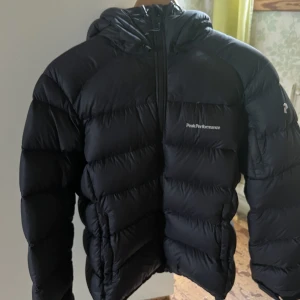 Peak Performance Jacka  - Peak performance jacka som passar både tjejer och killar. Nyskick och inte använd på 1 år. Ny pris 3000kr. Svart färg med en hint av marin blå. Säljer pga jag gått ner i storlek och den nu är för stor. 