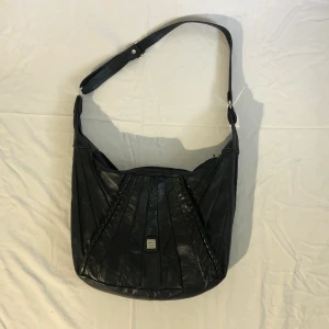 Svart läderväska - En så snygg svart läderväska med randiga detaljer, den är i äkta läder! Passar till allt och bandet går att justera