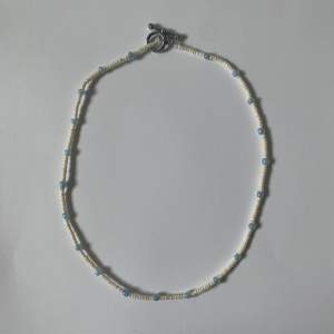 Ett super fint halsband med vita och blå pärlor. -handgjort och oanvänt- 😊
