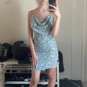 cowl neck klänning - en ljusgrön/blå blommiga cowlneck klänning! säljer då jag inte gillar hur den sitter o ser ut på mig:) köpt på nakd för längesen, använd typ 2 ggr så i bra skick. kolla gärna min profil för mer 💓