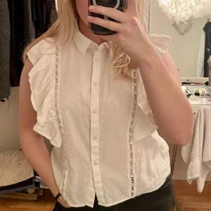 Vit blus med brodyr  - En jättesött vit blus utan armar som har superfin brodyr på. Säljer pga används inte längre. 