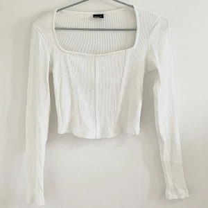 Vit långärmad - Slutsåld vit långärmad tröja med korsettliknande detaljer på framsidan från Gina Tricot. Säljs då den inte kommer till användning, använd max 3-4 gånger. Inga fläckar och är inte sliten. Köpt för 199kr, säljer för 50kr.