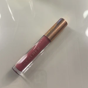 Läppglans  - Läppglans i en rosaaktig färg. Aldrig använd 