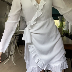 Studentklänning - Söt studentklänning med omlott stängning. Använd en gång på min mottagning. Långa ärmar och perfekt längd. Jag är 164 cm