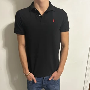 Svart polo Ralph Lauren piké  - Svart Ralph Lauren piké i storlek L men den är liten i storleken och passar S/M 