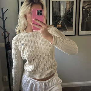 Kabelstickad Ralph Lauren - Kabelstickad Ralph Lauren tröja i beige med marinblå logga. Storlek S, något strävare material. Använd flera gånger. 💛