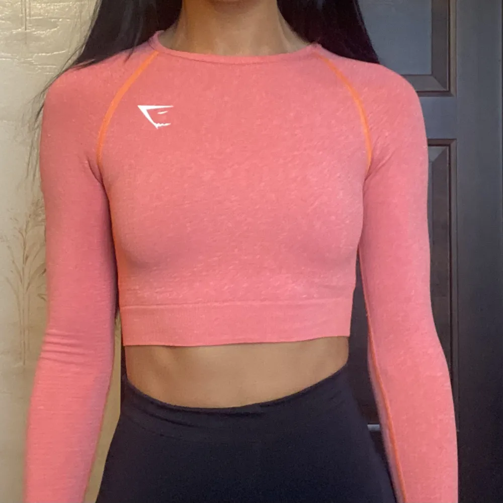 Crop top från gymshark med tumhål från Vital Seamless 2.0-kollektionen. Färgen heter orange marl och den är orange-rosa. Använts ca 10 gånger och är i bra skick. . Toppar.