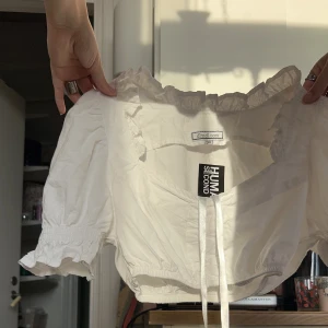 Vit croppad blus - SÅ SÖT croppad blus. Köpt på Humana, lappen kvar och aldrig använd 💕 I storlek 36 men passar definitivt en 34-32. Fråga vad som helst om plagget, en snabb affär uppskattas 🥰