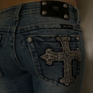 Miss Me jeans strl 27 - Väldigt lågmidjade jeans från Miss Me i storlek 27 från 00-talet. Fickorna är blingade med detaljer i pärlor.