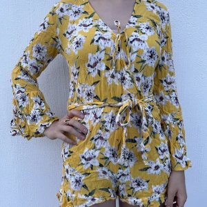 Flowy byxdress - Gul, söt, flowy byxdress med blommotiv. Bekväm och perfekt till varma dagar när man bara vill slänga på sig något. 