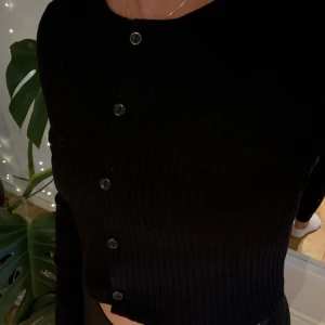 Långarmad tröja kroppad - Svart kroppad tröja med knappt från monki. Inget slitage på tröjan.  Skriv privat om intresse finns!