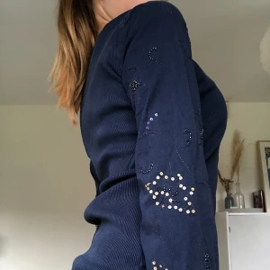 Mörkblå långärmadtopp med paljetter - Supersöt mörkblå långärmad topp i ribbat material med passa fina paljetter och stenar på armarna. Tröjan är i storlek M men är sitter bra på mig som vanligtvis bär storlek S. Hör av dig för fler bilder💋💘