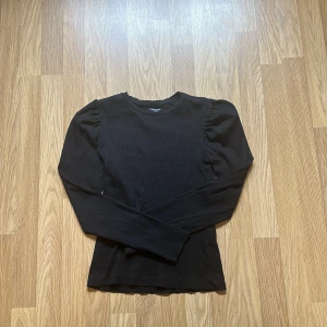 Svart tröja med puff i axlarna - Tröjan är använd några gånger men i fint skick från pieces. 
