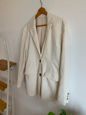 Oversized kavaj  - Oanvänd kavaj med snörning back i offwhite. 