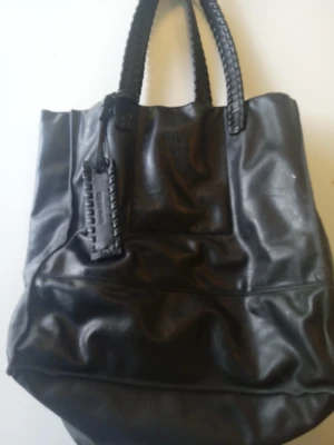 Ceannis skinnväska  - Snygg skinnväska från märket Ceannis köpt på Åhlens dyr i nypris fint skick med flätade handtag äkta skinn 