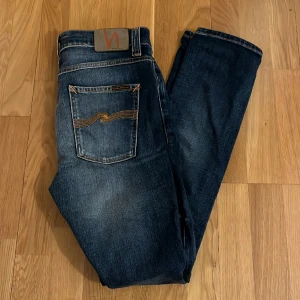 Nudie Jeans - Ett par väldigt schyssta Nudie Jeans i en blå färg, med en slimfit passform. Jeansen har inga som helst deffekter, alltså i ett gott skick. Nypris 1600. Skriv för fler bilder eller om ni har frågor.