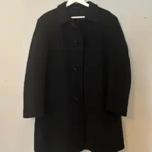 Mörkblå, nästan svart vintage kappa i ull och Kashmir! Har ingen storlek men jag skulle säga runt L men kan bäras oversize! Midi längd, superbra skick! Aldrig använd av mig 💕