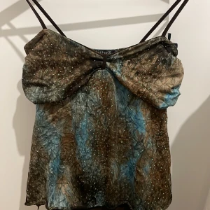 Topp - Säljer denna snygga topp med göittriga detaljer