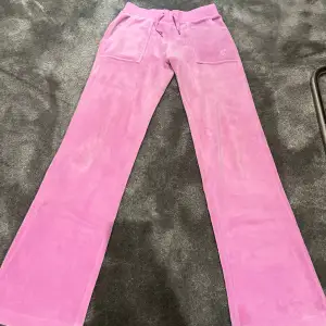 Rosa juicy couture byxor som inte används längre. Båda metallbitarna har åkt av på snörena 