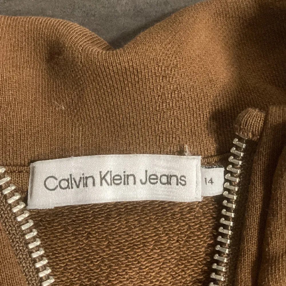 Säljer min Calvin Klein half zip i färgen brun då den har blivit för liten. Skicket är 8/10 och jag köpte den från KidsBrandStore. Pris kan diskuteras vid snabb affär. . Hoodies.