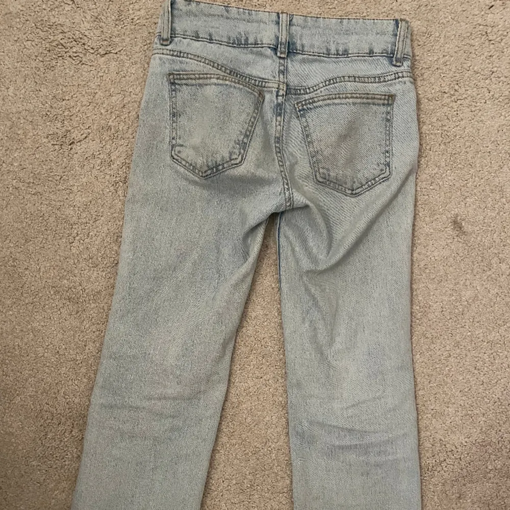 Lågmidjade bootcut/flare ljusblåa jeans från PULL & BEAR som inte finns att köpa längre. As snygga knappar och fina byxor, inga skador.Stl 32, skriv för fler bilder/ mått❤️. Jeans & Byxor.