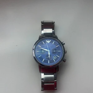 Armani klocka - Säljer en snygg Emporio Armani klocka i silver färg och mörkblått i uret.  Nästan helt ny, skicket är 9/10 med iprincip noll skador eller repor!  nypris: 1800kr  mitt pris: 850kr