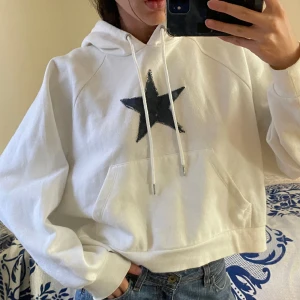 Vit hoodie med stjärna  - Jätteskön och mysig hit hoodie med en fastsydd blå stjärna på! Storlek M men passar perfekt för XS/S också då den är oversized! 