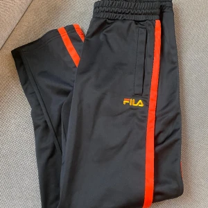 Fila button up trackpants - Säljer ett par snygga Fila trackpants med knäppning längs med benen. Köpa här på Plick men var för små för mig. Har vanligtvis storlek S-M. Fint skick 