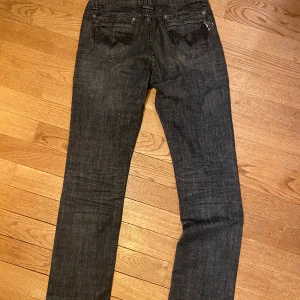 Lågmidjade jeans - Säljer dessa svarta lågmidjade Onado jeans. Jättefina detaljer på bakfickorna.  Storlek M 