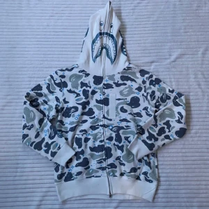 BAPE Space Camo Shark Full Zip Hoodie 🩵 - ☆ Jättefin Bape hoodie köpt nyligen, lyser i mörkret~ ☆ Helt ny, enbart provad! Tags och inköpskvitto finns. ☆ Storlek M och passar mig baggy som har strl 38. Om du har några frågor kontakta mig. Kolla gärna in min profil för fler plagg och mycket y2k! 💎