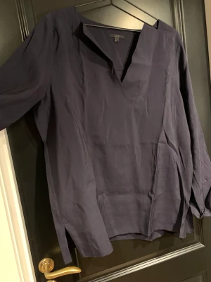 COS v-ringad blus - Mörkblå v-ringad blus från COS i storlek 42, aldrig använd därför i nyskick