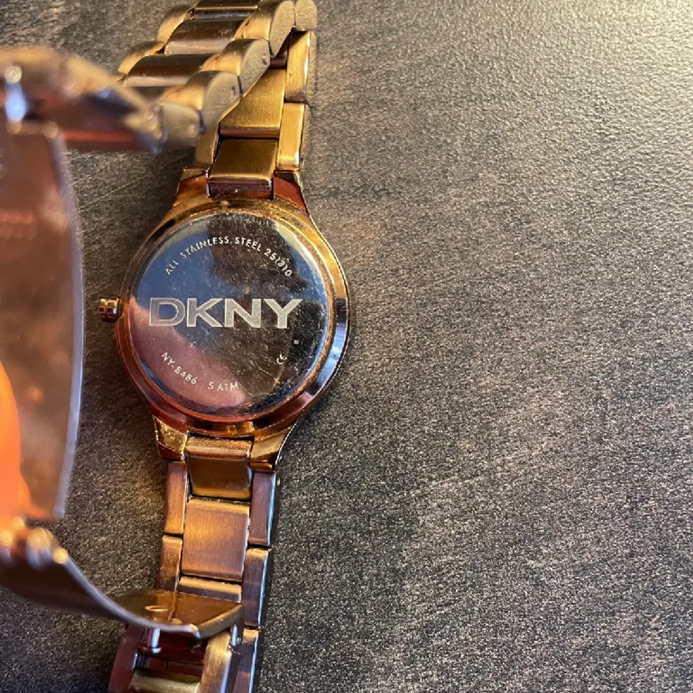 DKNY klocka i rosé med fina stenar runt uret. Har kortat av tre länkar men dessa följer med om man vill göra den större. Sparsamt använd så i mycket gott skick.. Accessoarer.