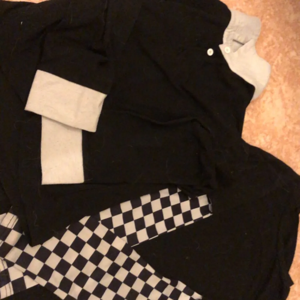 Båda för 50kr! En långarmad svart tröja med vitt och svart rutigt mönster på armarna. Den andra är en skjorta med vit krage och knappar. Blusar.