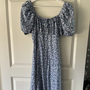 Klänning  - En fin blommig lång klänning med slit och dragkedja där bak💖